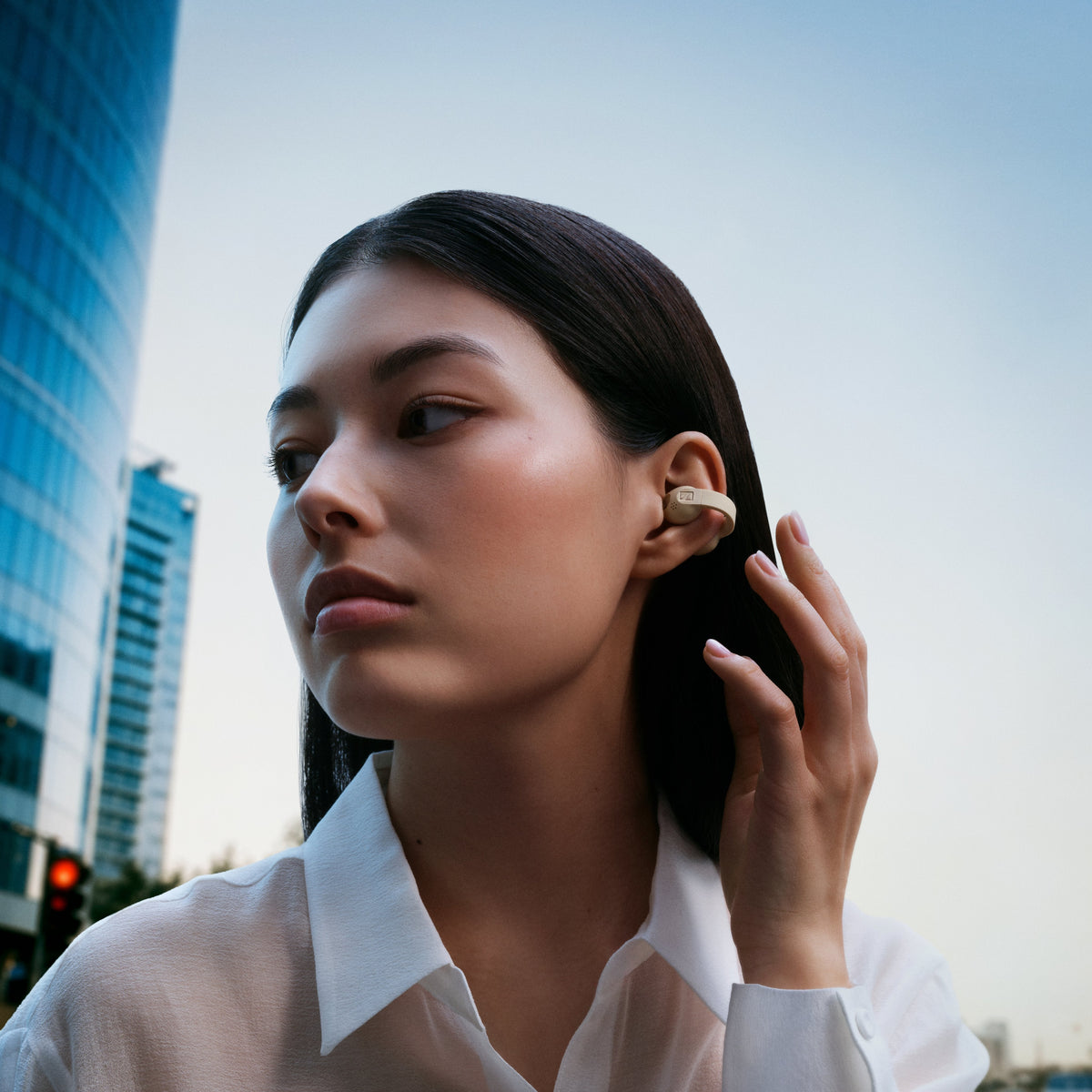Sennheiser ACCENTUM Clip – Model wearing Ice Blue earbuds outdoors